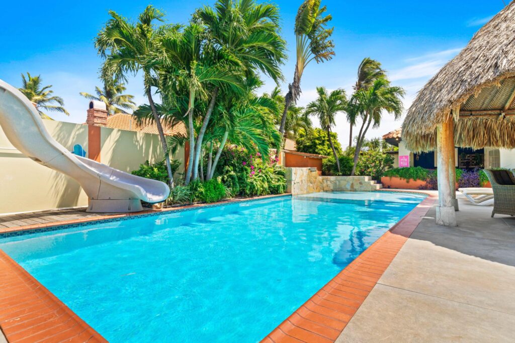 Private pool with water slide and tropical palms