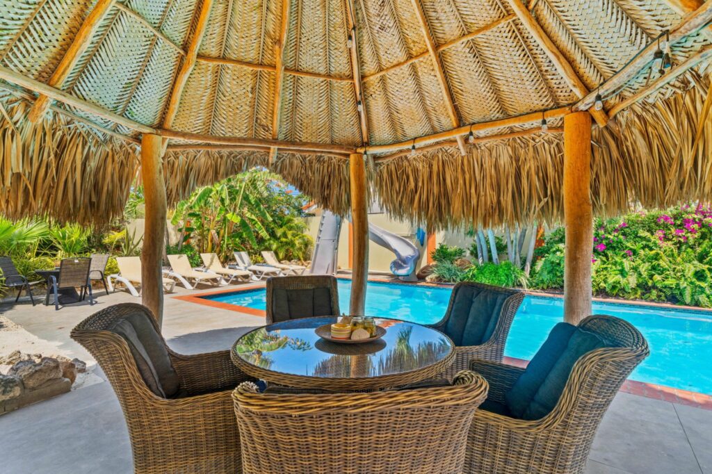 Wicker seating beneath the poolside palapa