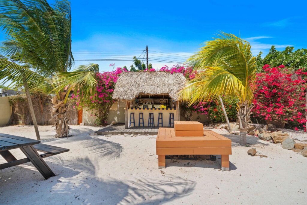 Outdoor bar surrounded by palms and bougainvillea at Villa Nirvana